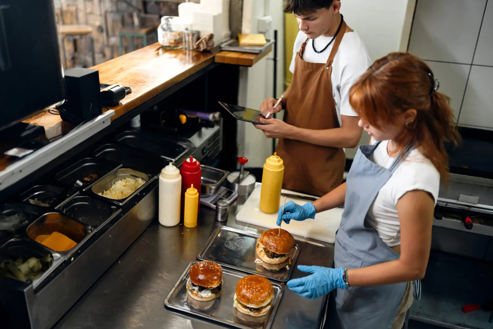 A teenager prepping food in a restaurant kitchen
