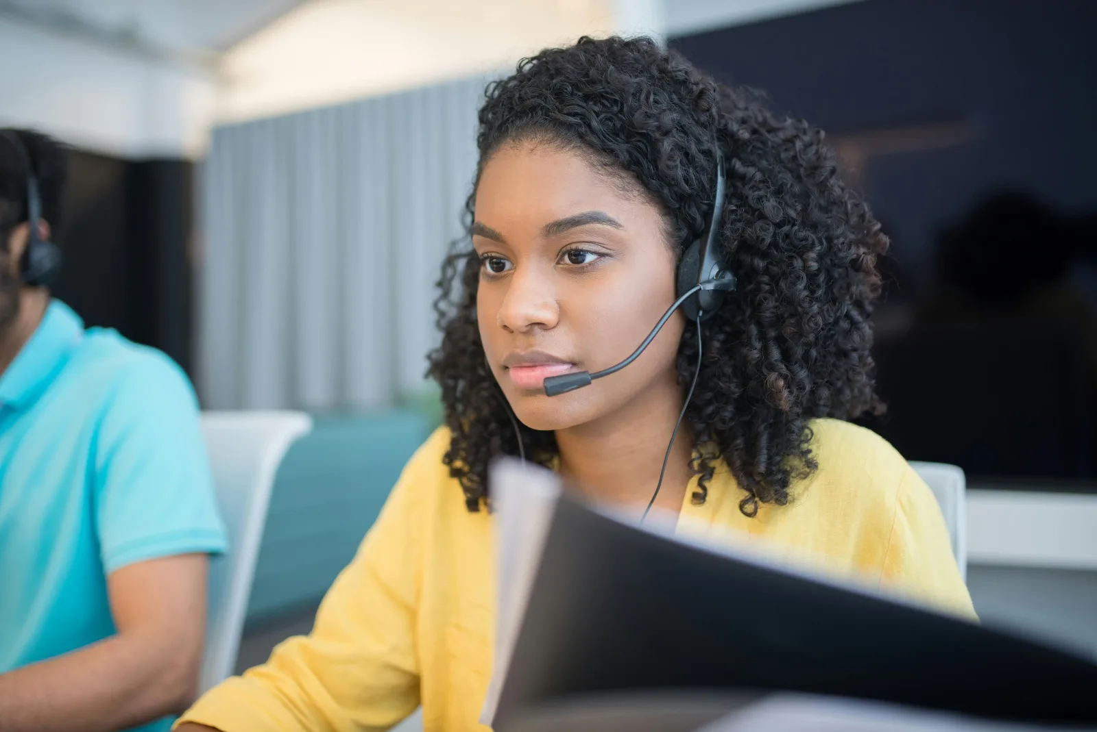 A young person working at a desk with a headset on